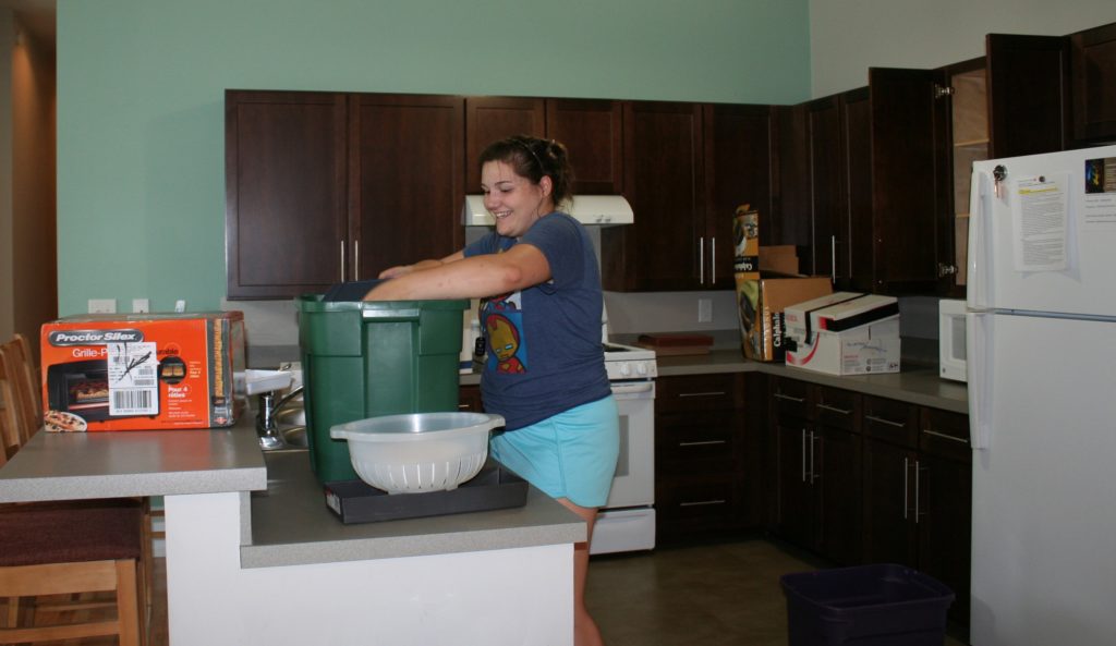 Samantha Kanios takes over setting up the kitchen in her shared loft. 