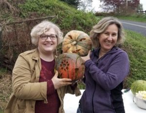 Kim Potcovaru and Jackie Smith, friends who will take CCE class together, holding pumpkins.