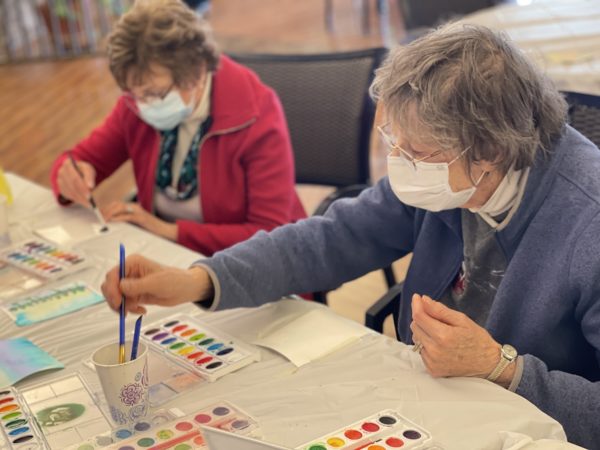 Two Garden Spot Village residents work together during a CCE watercolor demonstration at the retirement community.