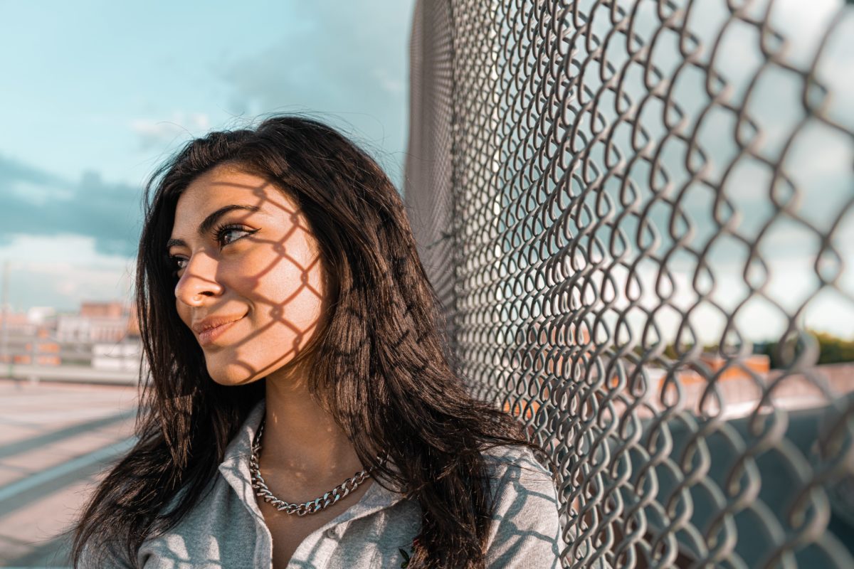photo of young woman against chainlink fence by Alex Spangler '22,  Graphic Design. 