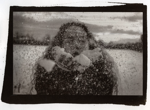 black and white photo of figure taken through wet glass.