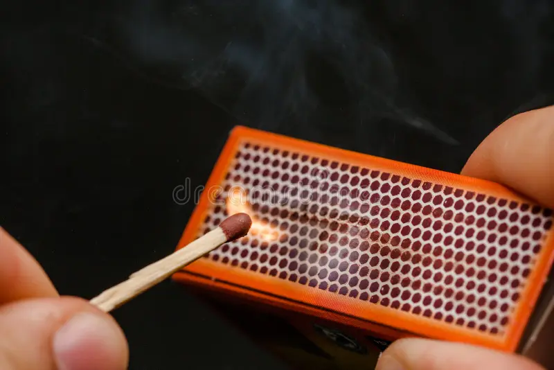 a match striking a matchbox and igniting