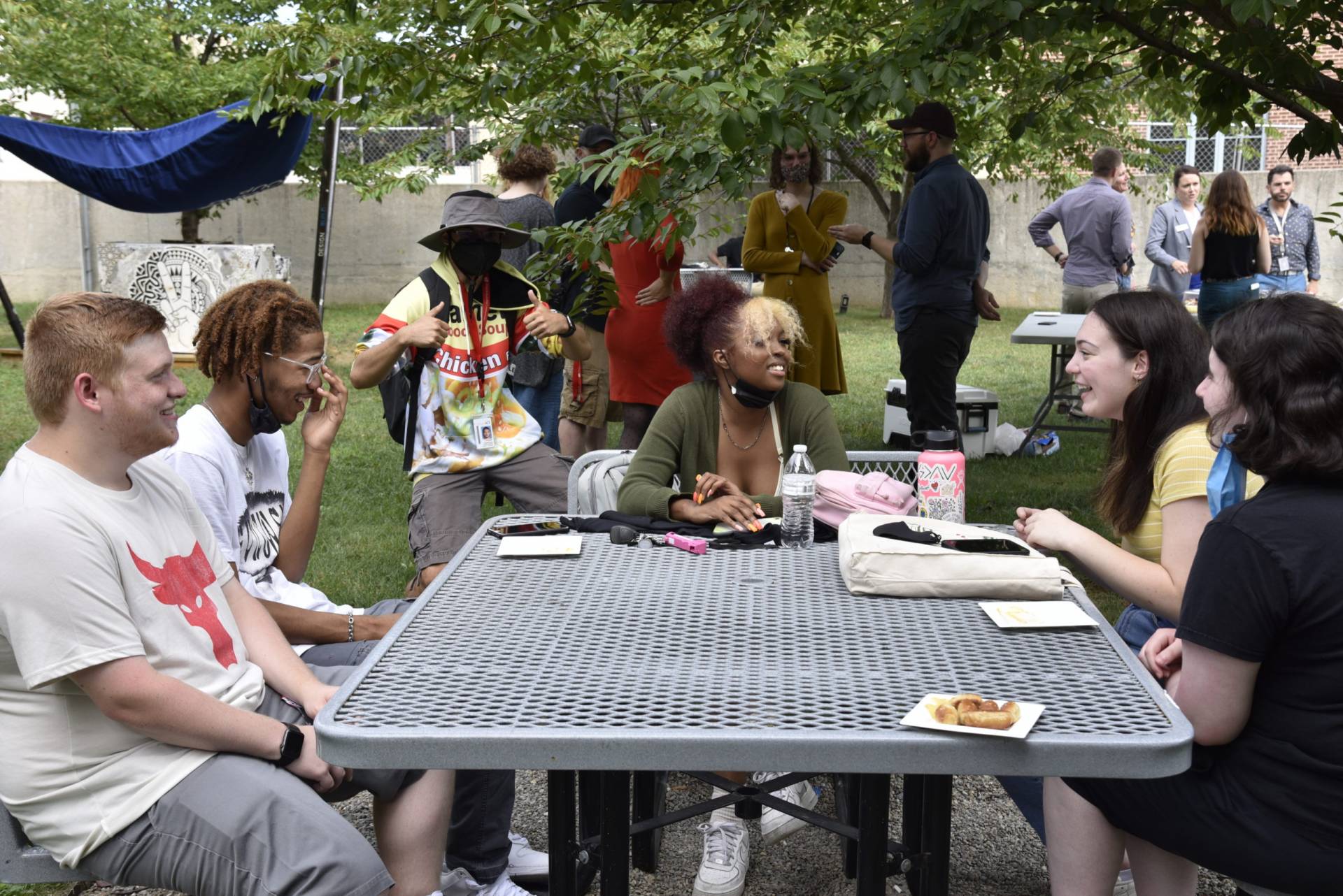 students gathered around a table in the art Garden .